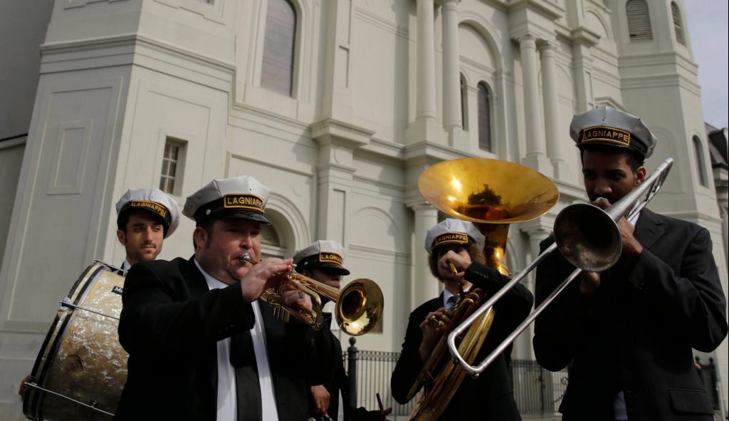 a brass band stands in front of a historic cathedral