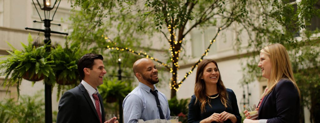 three people in professional dress  smile and drink