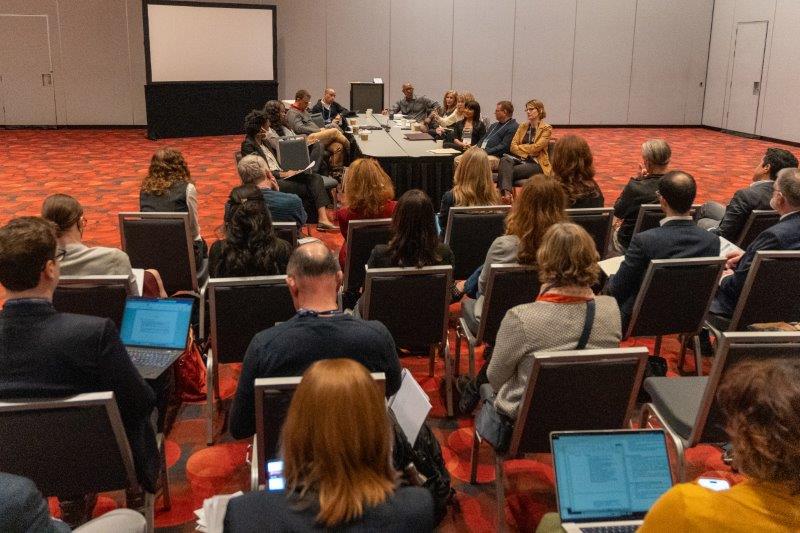 Photo of an AALS Discussion Group with law professors sitting around a table and in the audience